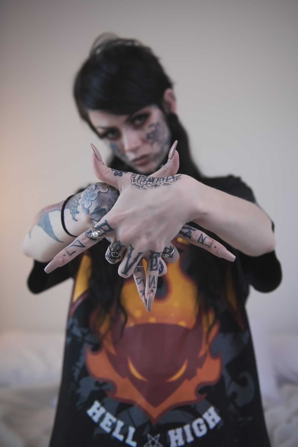 Tattooed Female hands are in the shape of a pentagram